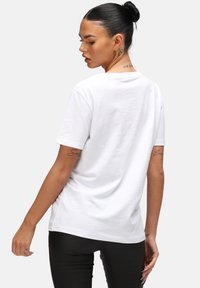 White cotton t-shirt with a round neckline and short sleeves, featuring a relaxed fit and a smooth texture. Minimalist design, no patterns.