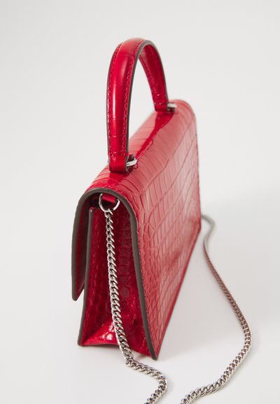 Red faux crocodile leather handbag with a structured design, featuring a short handle and a silver chain strap. Smooth, glossy texture.
