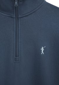 Marineblauer Pullover mit Viertel-Reißverschluss und einer kleinen weißen bestickten Figur, die auf der linken Brust einen Polo-Schläger hält.