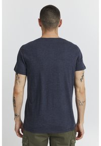 Mornarsko modra kratkotrajna majica s kratkimi rokavi iz mehkega, teksturiranega materiala; ima klasičen okrogel izrez in ravno prileganje.