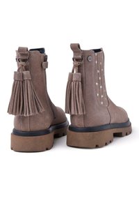 Stivaletti alla caviglia in suede marrone con suola chunky, zip laterale e frange decorative. Accentuati da motivi di stelle bianche sul retro.