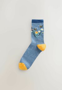 Blauw-witte gestreepte sok met gele teen en hiel. Voorzien van een bloemmotief met bijen en levendige kleuren, gemaakt van zachte stof.
