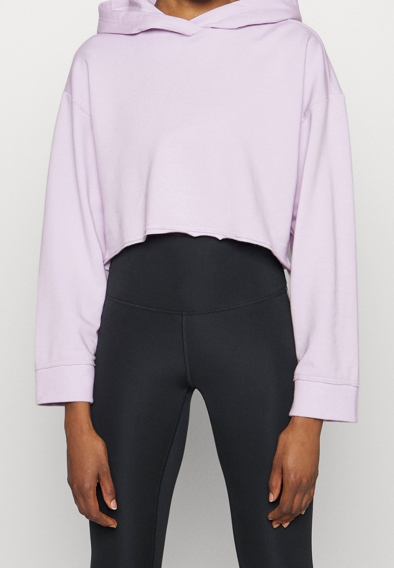 Felpa con cappuccio tagliata, di un leggero colore lavanda, con maniche lunghe e orlo grezzo, abbinata a leggings neri dal piacevole texture.