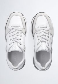 Chaussures de sport blanches et grises avec une tige en cuir lisse, des accents métalliques, des panneaux texturés et une semelle en caoutchouc profilée basse.