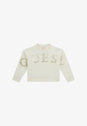 Felpa a maniche lunghe color crema con colletto a girocollo, decorata con lettere in paillettes dorate che formano la scritta "GUESS" sul davanti e sulle maniche.