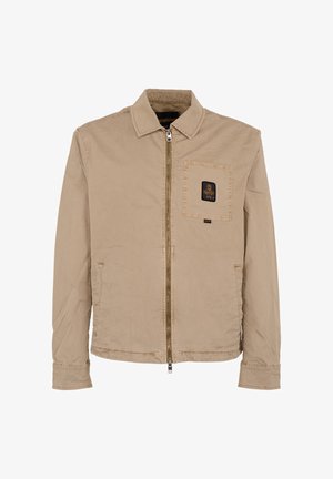 Beige jas met ritssluiting, kraag, lange mouwen, een borstzak aan de voorkant met een zwart label met een gouden embleem, en twee zijzakken.