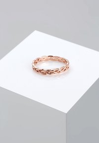 Anello in oro rosa con design intrecciato e dettagli a intaglio. Finitura liscia, forma arrotondata e vestibilità regolabile.