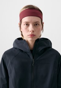 Black hooded jacket with a zip front, featuring a fitted maroon headband. The headband has a logo, and the fabric appears smooth.