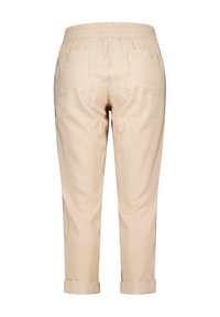 Pantalons légers beiges avec une taille élastique, deux poches arrière et des ourlets roulés au bas. Texture lisse, design ajusté.