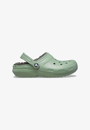 Hellgrüner Clog aus synthetischem Material mit strukturiertem Design, Belüftungsöffnungen und einem flauschigen grauen Futter. Verstellbarer Hinterriemen enthalten.