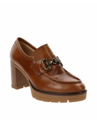 Mocasines de mujer en cuero marrón con tacón de bloque de madera grueso, suela de goma y cadena decorativa de metal oscuro en la parte superior.