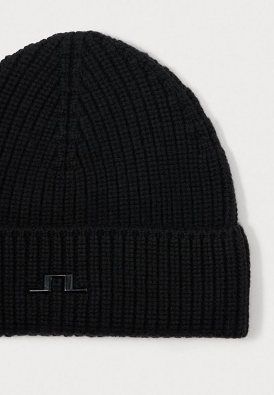 Gorro de lana negro con textura acanalada, que presenta un dobladillo doblado y un pequeño logo negro en la parte frontal.