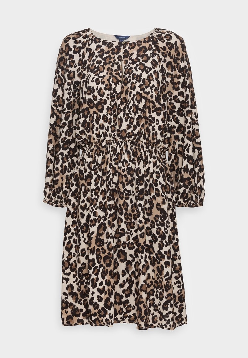 Robe imprimée léopard avec des manches longues, un col rond et un détail élastique à la taille, fabriquée à partir d'un tissu léger et texturé dans des tons beiges et bruns.