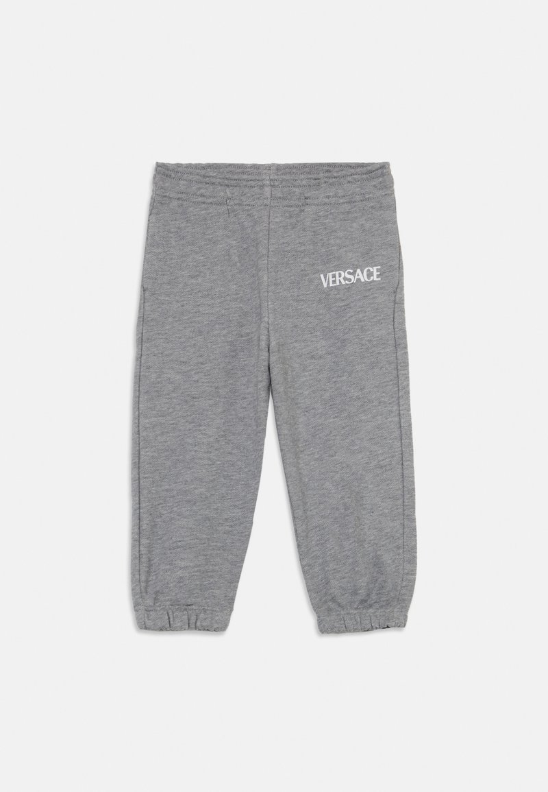 Sudadera gris con un diseño ajustado, cinturilla elástica, dobladillos con puños y un logo blanco de "VERSACE" en el muslo izquierdo.