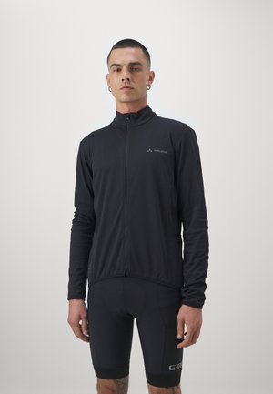 Veste de cyclisme noire avec un col haut et une fermeture éclair intégrale, fabriquée en tissu léger et extensible ; associée à un short noir ajusté comportant des accents.
