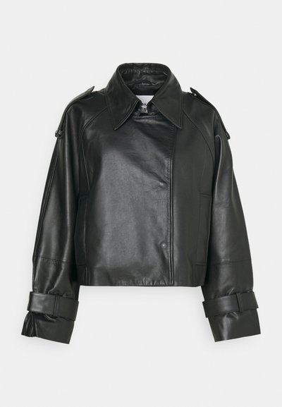 Veste en cuir noir coupée avec un col structuré, des manches larges et des poignets ceinturés ; présente une texture lisse et des coutures angulaires.
