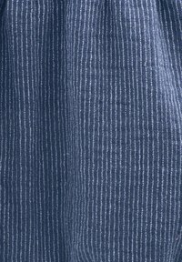 Dunkelblauer Stoff mit vertikalen weißen Streifen, der ein strukturiertes, gewebtes Muster aufweist. Das Material wirkt weich und leicht.