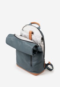 Rucksack aus blauem wasserdichtem Material mit Rolltop-Design, hellbraunen Lederakzenten und einem strukturierten grauen Innenraum mit mehreren Taschen.