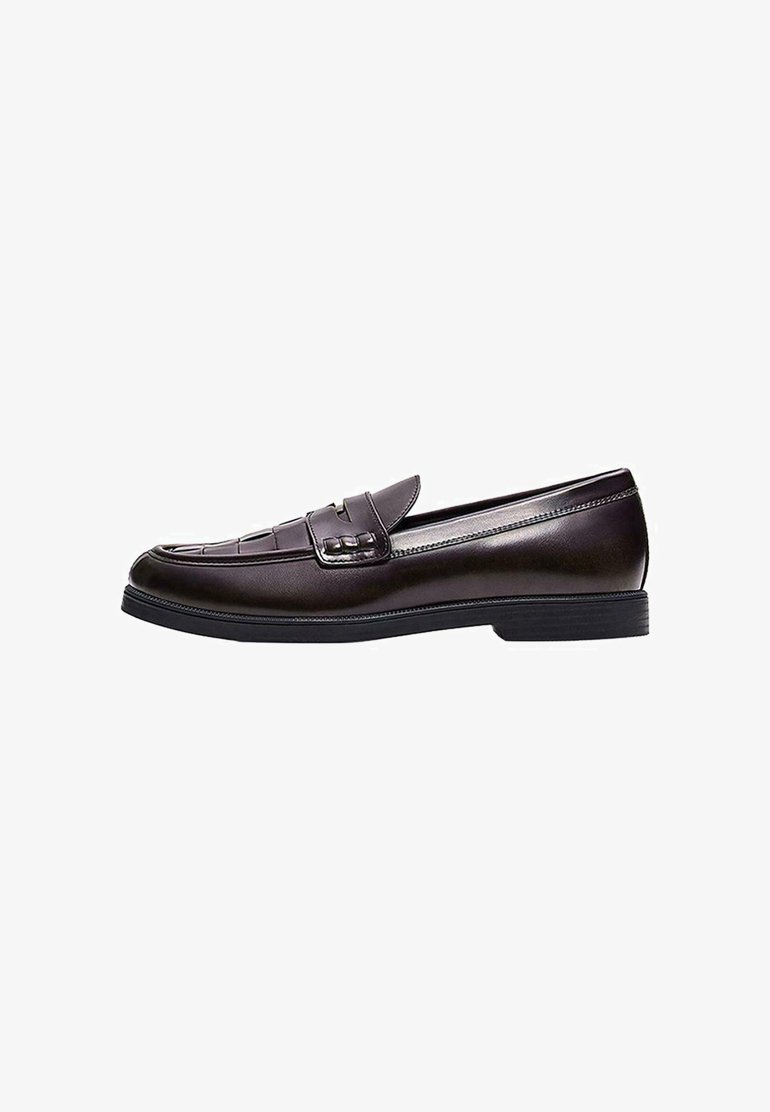Mocassin en cuir marron foncé avec un petit talon, des détails cousus sur l'avant et une bride décorative sur le dessus.