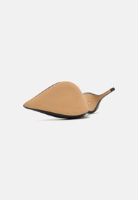 Escarpin à bout pointu avec une tige en cuir couleur sable, une texture lisse et une semelle extérieure noire. Présente un talon fin et un design minimaliste.
