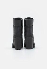 Černé kotníkové boty z hladké kůže s robustním podpatkem, se zahnutejším vrškem a jemným prošíváním podél stran.