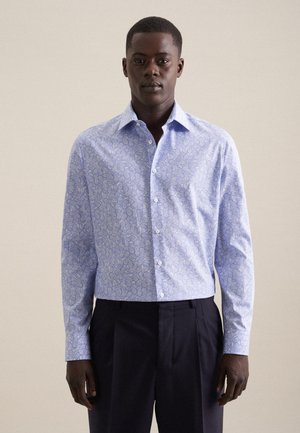 Camicia a maniche lunghe blu chiaro con motivo paisley in bianco e blu scuro. Colletto a bottoni con chiusura frontale. Tessuto in cotone.
