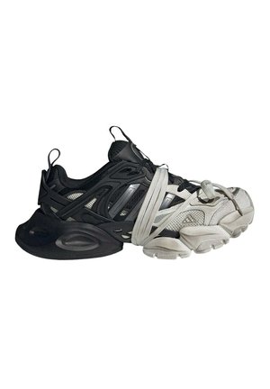 Sneaker bicolore nero e bianco con suola spessa, caratterizzata da lacci bianchi avvolti in modo lasco intorno al mesopiede e all’area delle dita.