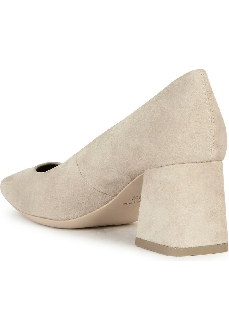 Scarpa beige in suede con tacco, punta affusolata e dettaglio a taglio, caratterizzata da un ampio tacco a blocco. Texture liscia con cuciture minime.