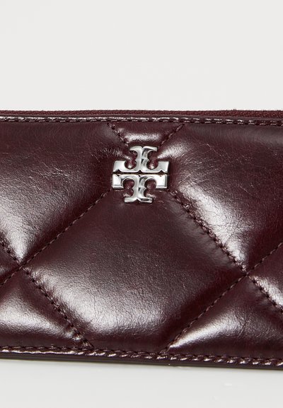 Süsimust nahast rahakott, millel on hõbedane logo aksessuaar. Omab teemantmustrite õmblust ja sujuvat, läikivat tekstuuri.