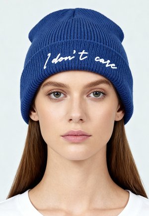 Blue knitted beanie with ribbed texture, featuring the white text "I don't care" embroidered on the front.