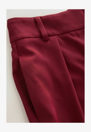 Burgundy trousers with a smooth texture, semi-tailored fit, and front pleats. Feature a wide waistband and side pockets.
