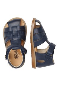 Námořnické modré kožené sandály s tkaným vpředu, otevřenými stranami, nastavitelným popruhem a světlou hnědou gumovou podrážkou.