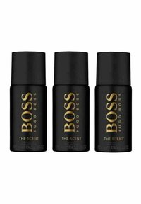 Kolme mustaa sylinterimäistä pulloa "BOSS THE SCENT", joissa on kultaiset kirjaimet ja matte-finiš, jokaisen kapasiteetti on 104,5 g.