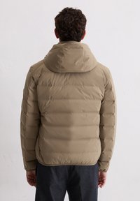 Beige Steppjacke mit Kapuze, mit gestepptem Design und glatter Textur. Rückansicht zeigt eine figurbetonte Form und elastische Bündchen.