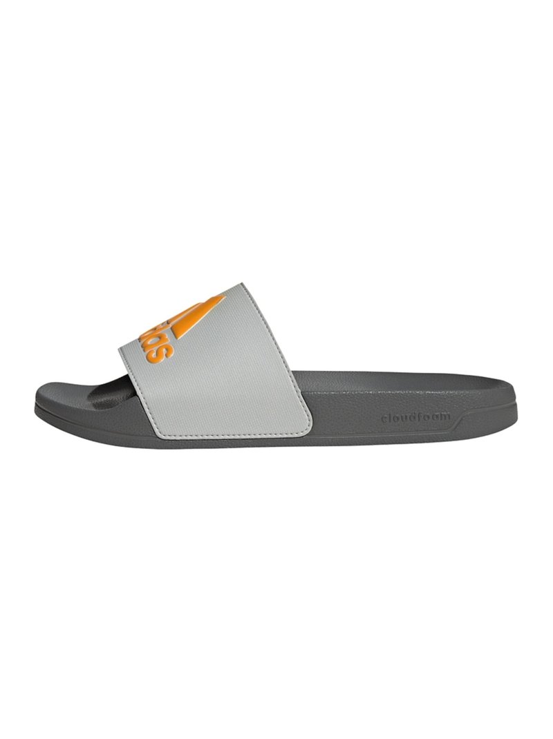Gray slide sandal featuring a gray synthetic strap with an orange Adidas logo. Cloudfoam footbed for cushioning. Flat sole design.