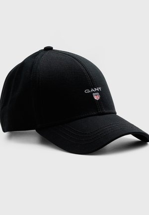 Black baseball cap with curved brim, stitched panels, and "GANT" logo with small shield emblem on front right side.