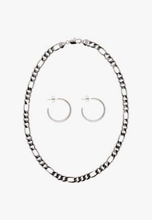 Zilveren ketting met schakelketting gecombineerd met eenvoudige gepolijste zilveren ronde oorbellen met stekker achterkanten op witte achtergrond.