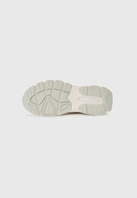 Shoe sole with a textured, light green rubber surface. Features deep grooves for traction and a molded design for support and flexibility.