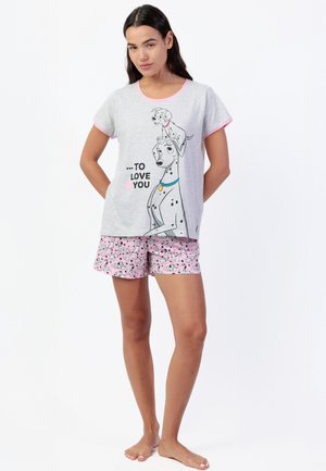 Mujer que lleva una camiseta de manga corta con temática de dálmatas en gris y rosa, con el texto "To Love You", y pantalones cortos rosas a juego con estampado de dálmatas.