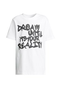 Balta medvilninė marškinėliai trumpomis rankovėmis su ryškiu juodu grafiti stilius tekstu: "SVAJOK, KOL TAI TAPO TIEA REALYBE", centruoti.