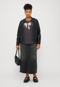 Black faux leather jacket, dark grey shirt with a light pink bow graphic, denim skirt, black shoes, and a black handbag.