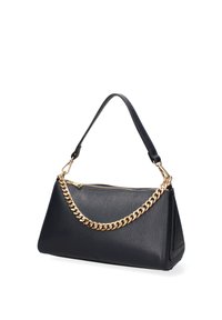 Sac à main en cuir noir texturé avec fermeture éclair supérieure, poignée courte en cuir et bandoulière décorative en chaîne dorée.