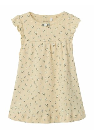 Robe florale jaune en tissu côtelé, dotée de manches volantées et de détails en boutons, avec une taille froncée et de petits motifs de fleurs vertes.