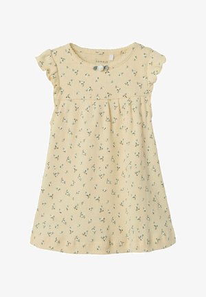 Robe florale jaune en tissu côtelé, dotée de manches volantées et de détails en boutons, avec une taille froncée et de petits motifs de fleurs vertes.