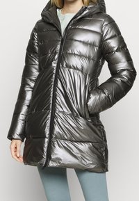 Nafouklá černá metalická parka s kapucí, svislým prošitím, plným zipem a dvěma postranními kapsami pro větší funkčnost.