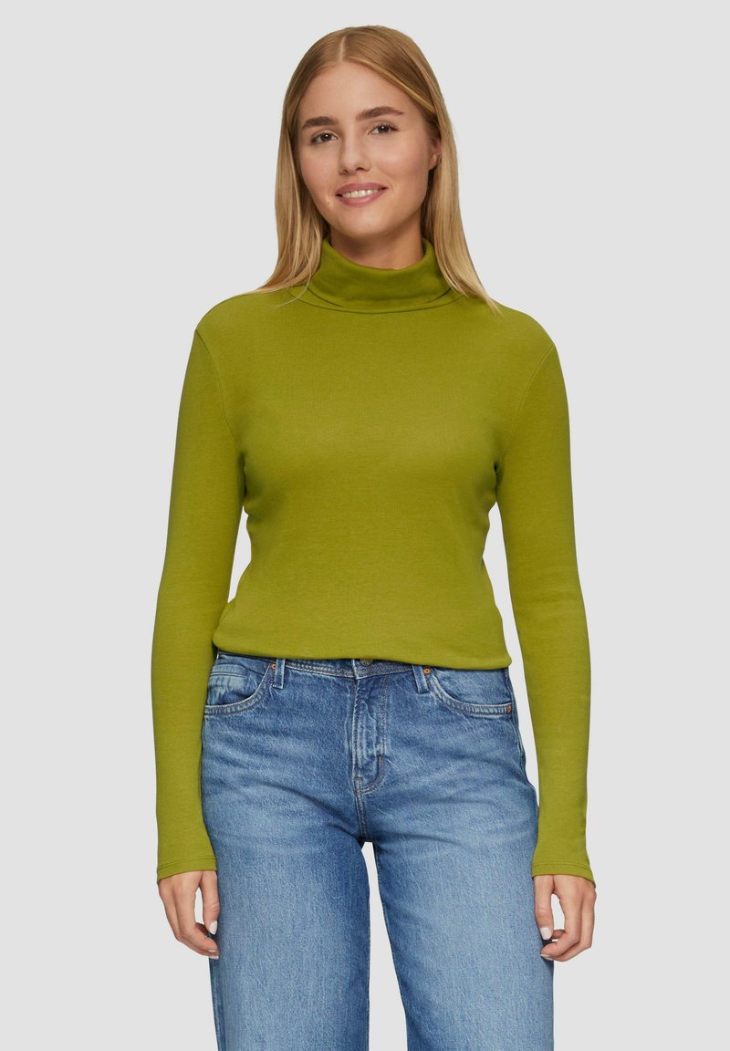 Olivgrüner Rollkragenpullover aus glattem Stoff, taillierte Passform mit langen Ärmeln, kombiniert mit hellblauen Jeans.