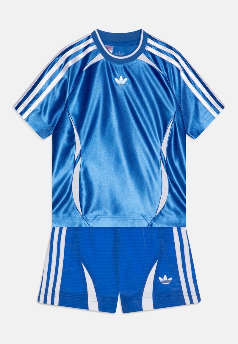 Modra športna garnitura Adidas, ki vključuje majico s kratkimi rokavi in kratke hlače. Gladek, sijoč material z belimi navpičnimi črtami in logotipom.