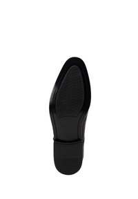 Suela de zapato de vestir de cuero negro con un patrón texturizado. Presenta un borde frontal liso y un ligero tacón. Marcado con la marca "WINTER".