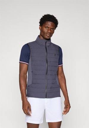 Insulated gray vest with a high collar, front zipper, and side pockets. Layered texture and fitted design over a navy shirt.