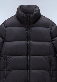 Zwarte pufferjack met een hoge kraag, voorzien van horizontale stiksels, twee ritszakken aan de zijkant en een glad, glanzend oppervlak.